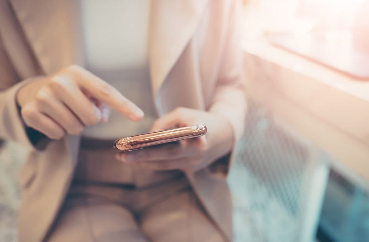 Woman in a suit using her iphone
